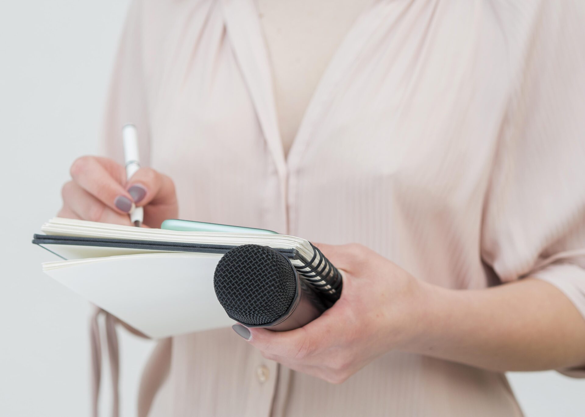 Medium shot woman holding microphone and writing notes